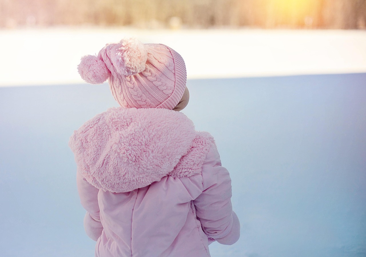 Young child in a snowsuit sitting in deep powder snow