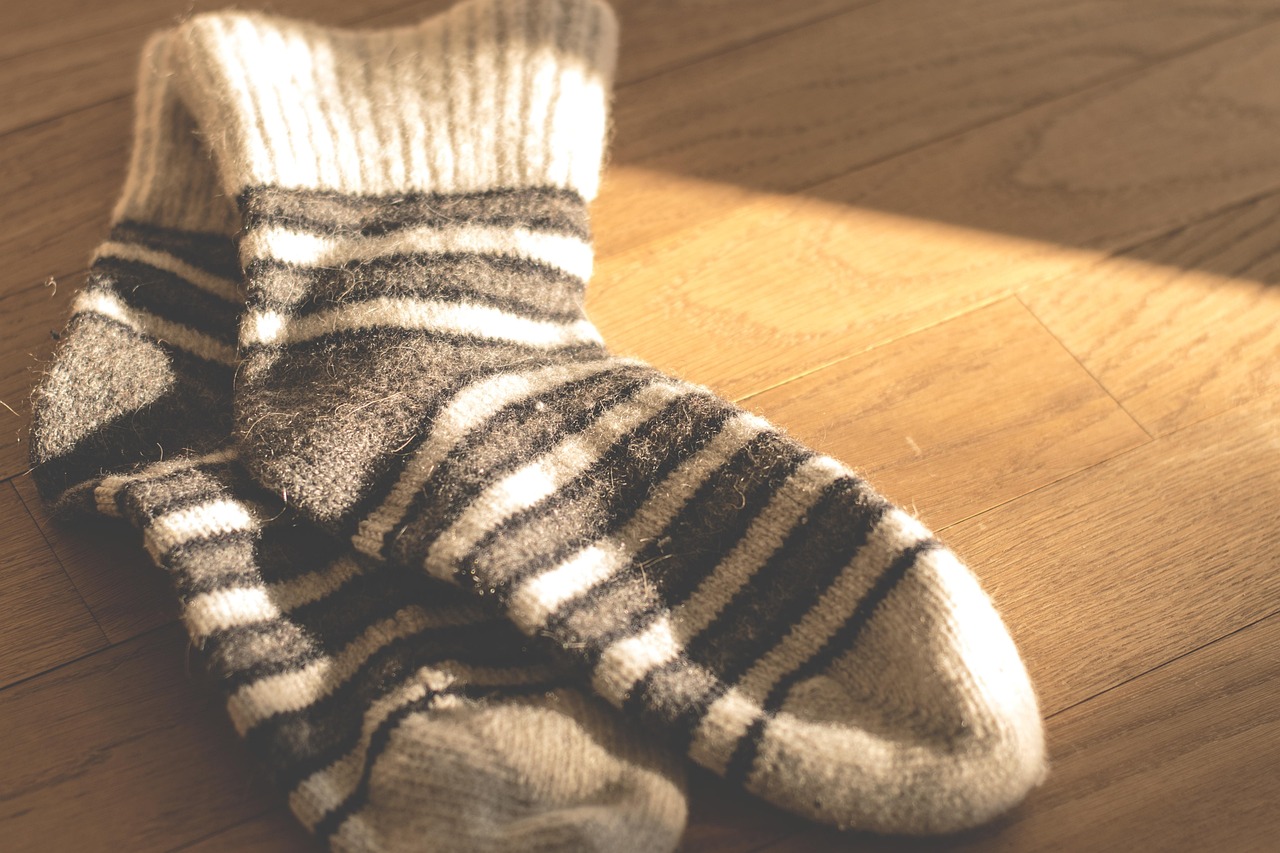 Knitted wool socks laid on a blanket, standing for the first layer