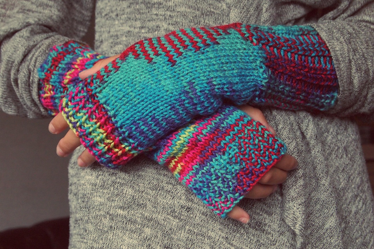 Hands in knitted wool gloves, illustrating the layered system for the hands