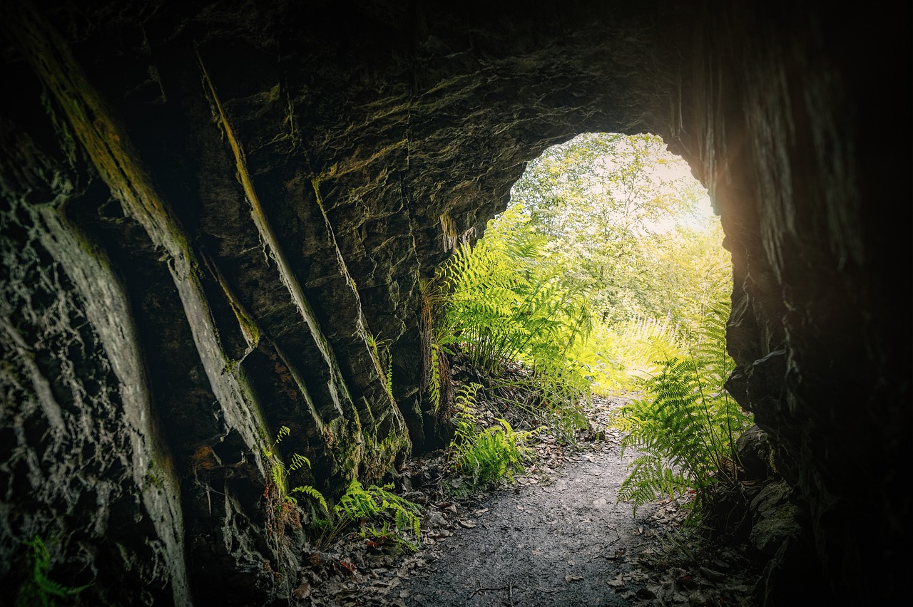 Tunnel creusé dans la roche éclairé, semblable à la caverne souterraine de SantaPark