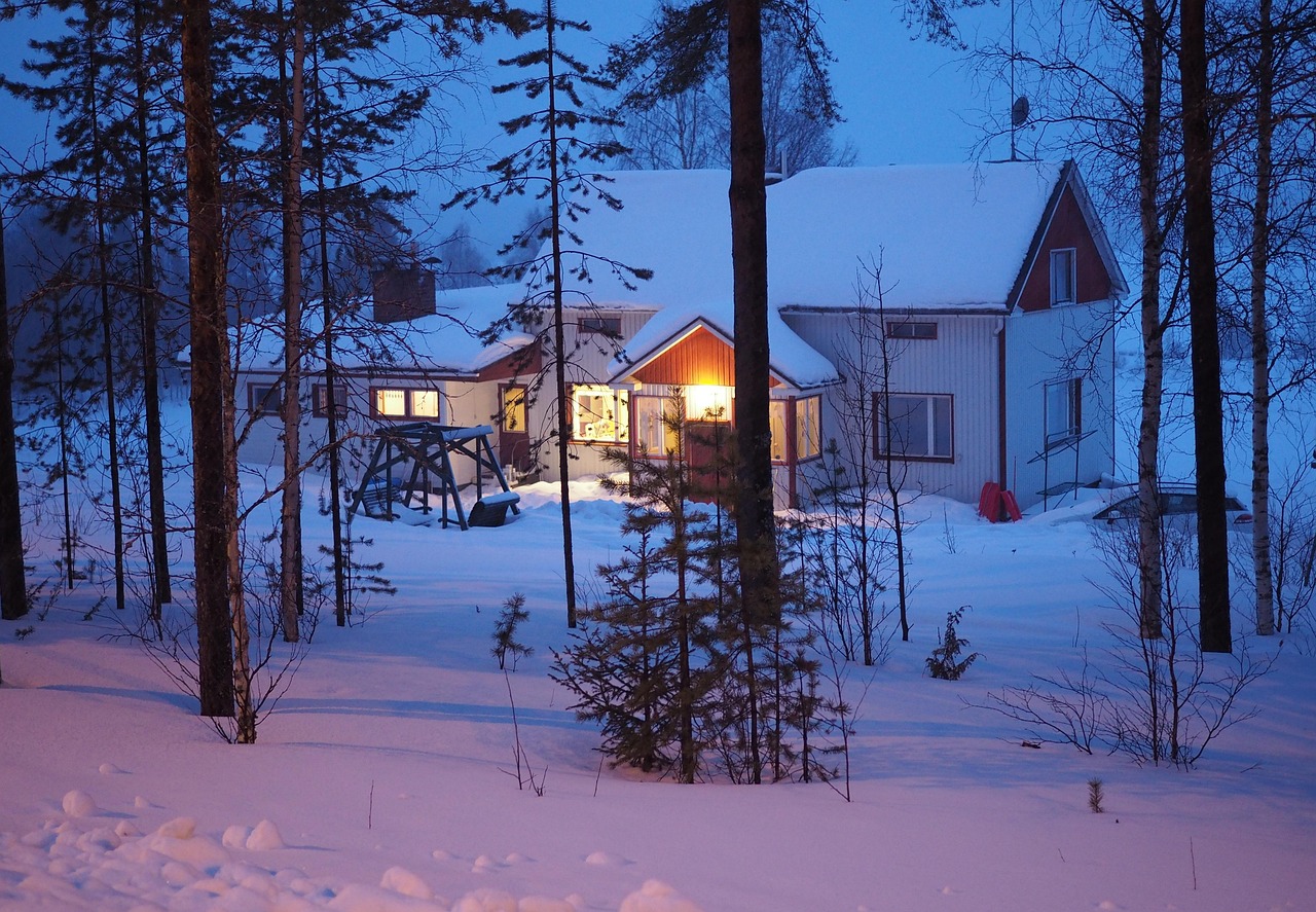 Isolated wooden cabin in a snowy Finnish Lapland forest at night